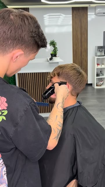 Barber pažljivo oblikuje frizuru klijenta u Blendi